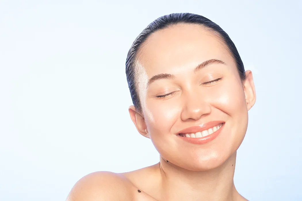 Asian Woman with glowing skin smiling