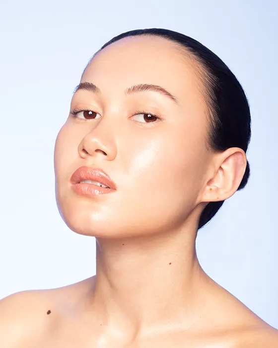 Asian Woman with glowing skin striking a confidence pose